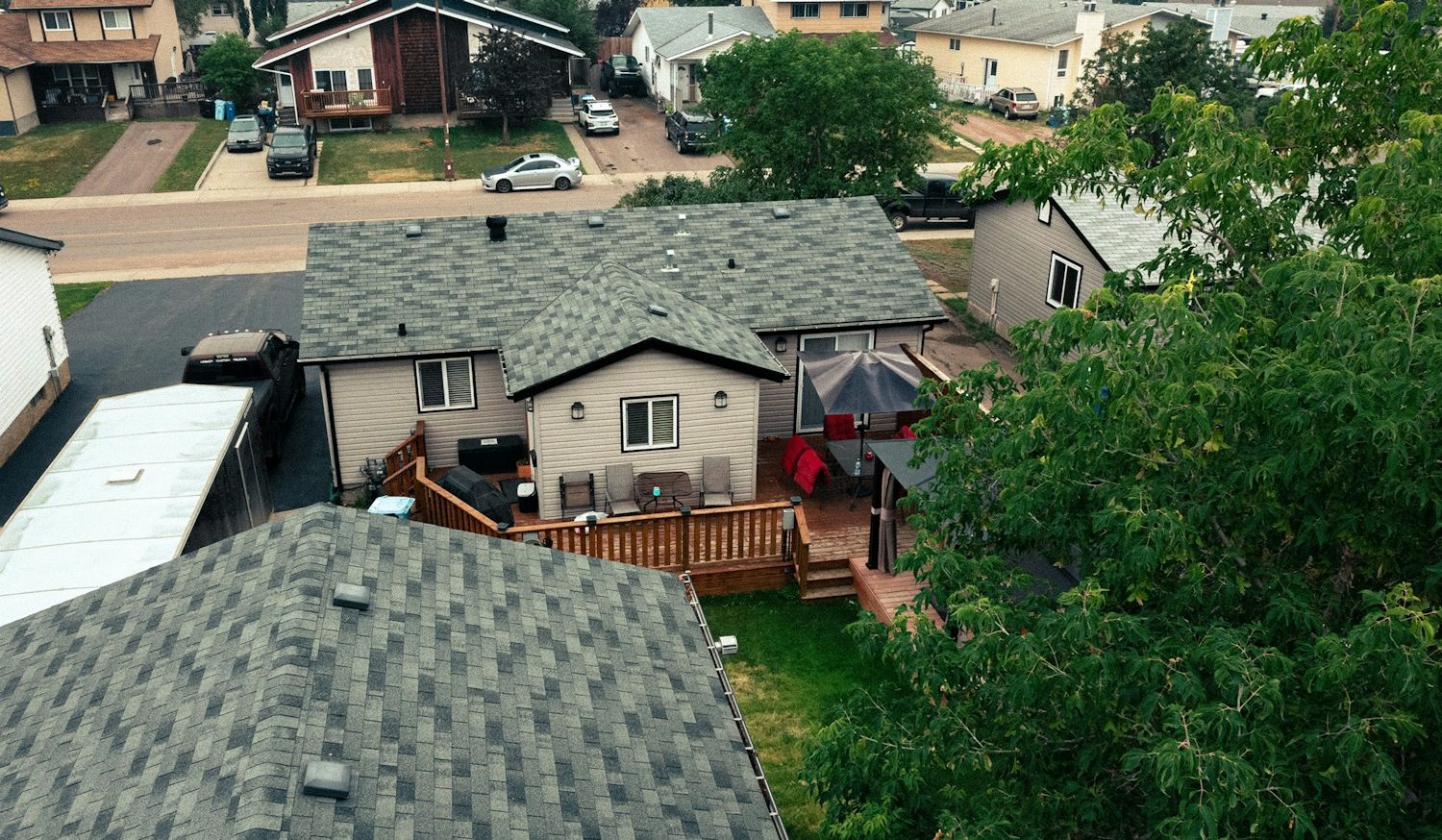 Residential homes with well-maintained roofs and backyard patios.